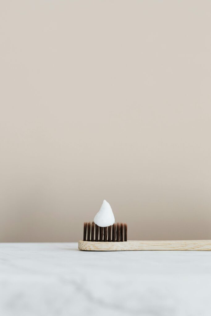Elegant minimalist photo of a bamboo toothbrush with a dollop of toothpaste, ideal for hygiene themes.